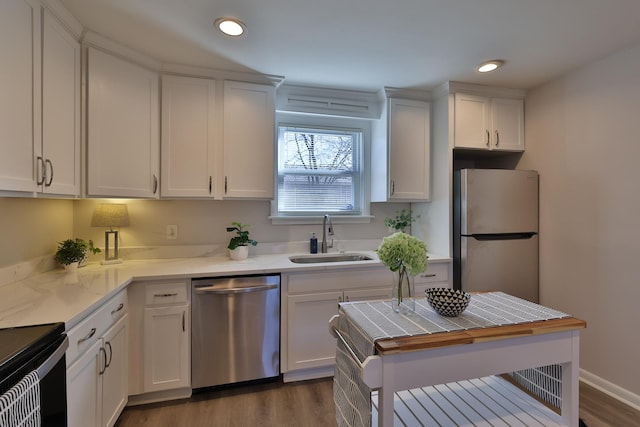 kitchen with white cabinetry, appliances with stainless steel finishes, dark hardwood / wood-style flooring, and sink