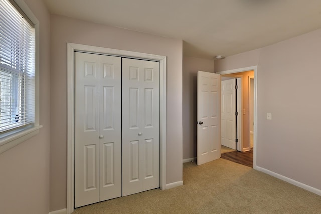 unfurnished bedroom with light carpet and a closet