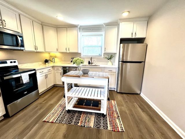 kitchen featuring stainless steel appliances, white cabinetry, sink, and dark hardwood / wood-style flooring