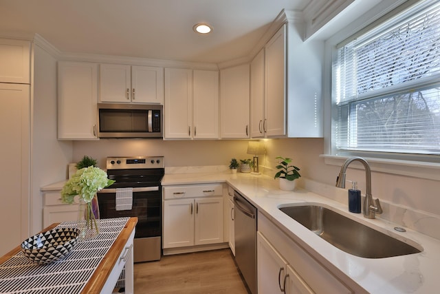 kitchen featuring white cabinetry, sink, wooden counters, and appliances with stainless steel finishes