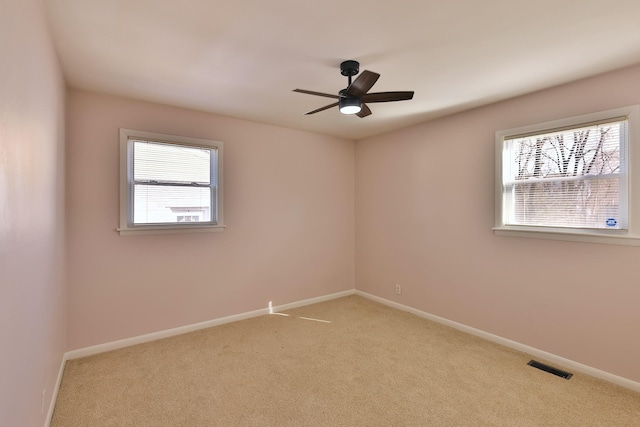 empty room featuring light colored carpet and ceiling fan