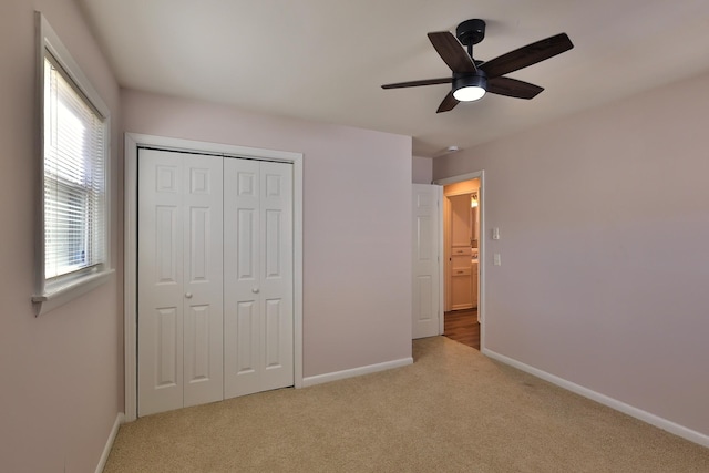 unfurnished bedroom featuring light colored carpet, ceiling fan, and a closet