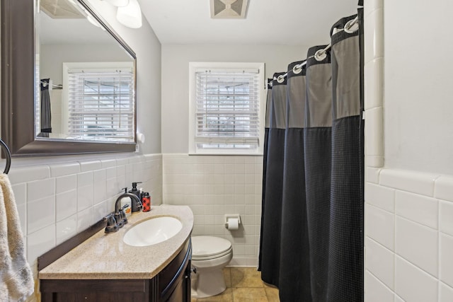 bathroom featuring tile walls, vanity, curtained shower, tile patterned floors, and toilet