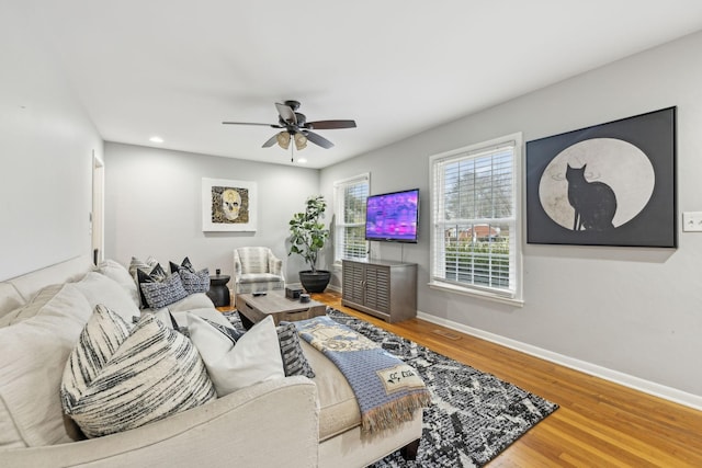 living room featuring ceiling fan and hardwood / wood-style floors