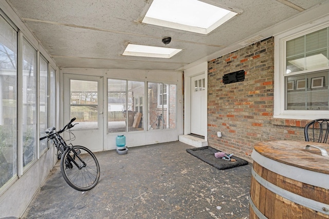 unfurnished sunroom with a skylight