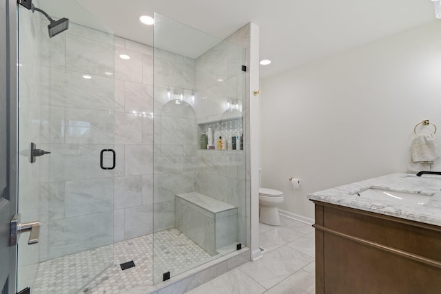 bathroom with vanity, toilet, and a shower with shower door