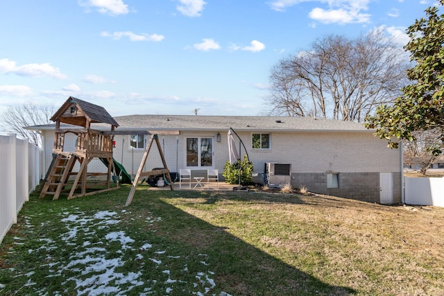 back of property with a lawn, a playground, and a patio area