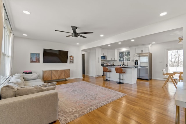 living room with ceiling fan and light hardwood / wood-style floors