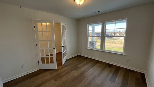 unfurnished room with dark hardwood / wood-style floors and french doors