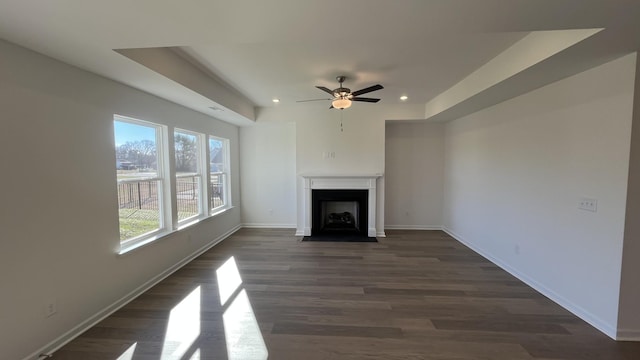 unfurnished living room featuring dark hardwood / wood-style floors and ceiling fan