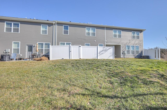 back of property featuring central AC and a lawn