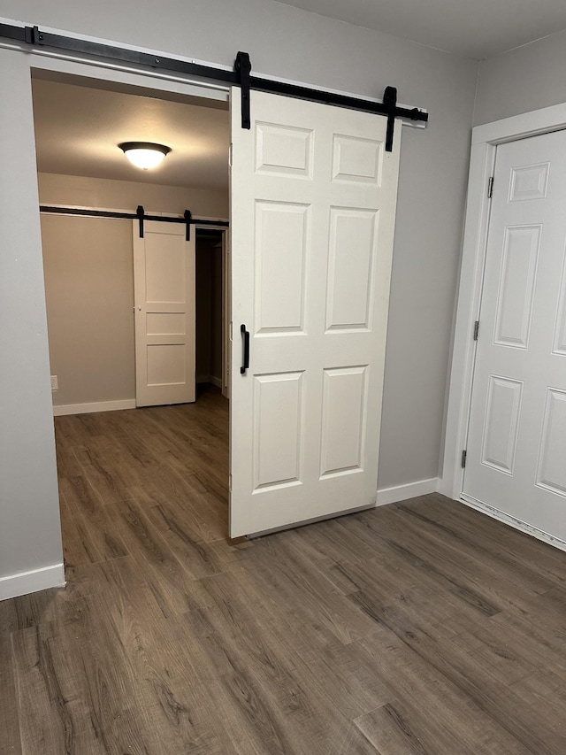 interior space featuring a barn door and dark hardwood / wood-style floors