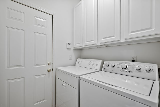 washroom featuring cabinets and washer and clothes dryer