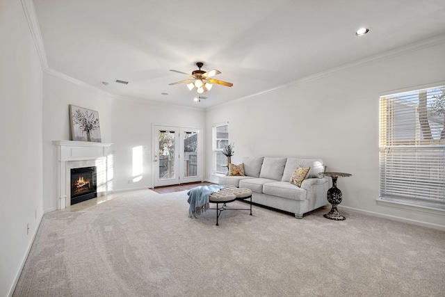 carpeted living room with ceiling fan, ornamental molding, and a high end fireplace