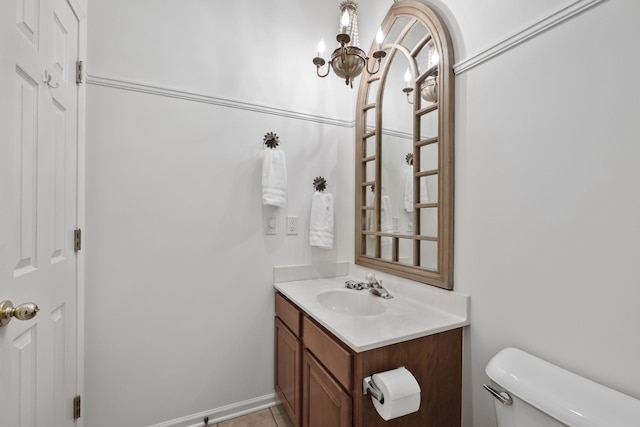 bathroom featuring vanity, toilet, and an inviting chandelier