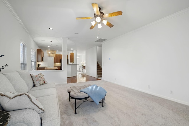 carpeted living room with crown molding and ceiling fan with notable chandelier