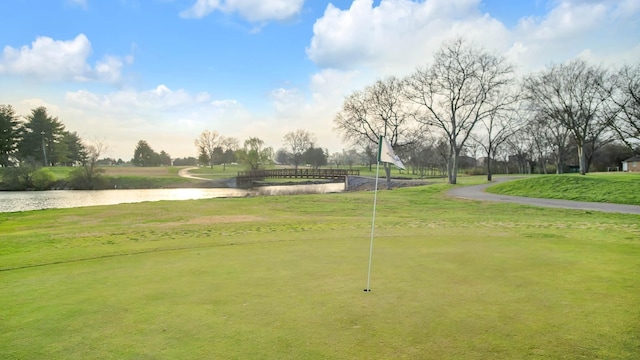 view of home's community with a water view and a lawn