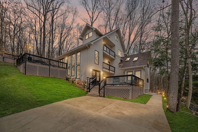 exterior space featuring a wooden deck and a lawn