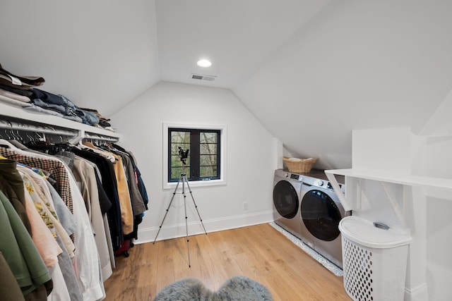 clothes washing area featuring hardwood / wood-style floors and washer and dryer