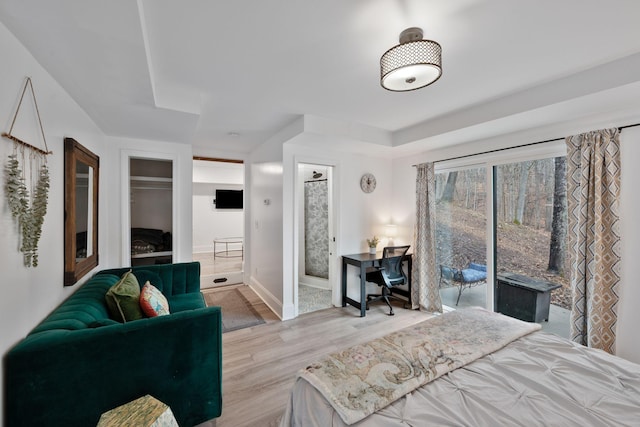 bedroom featuring ensuite bath and light hardwood / wood-style flooring