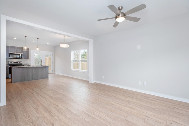 unfurnished living room featuring ceiling fan and light wood-type flooring