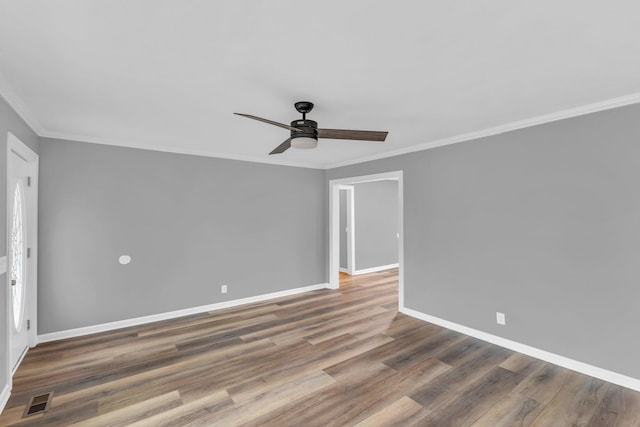 empty room with dark hardwood / wood-style flooring, crown molding, and ceiling fan