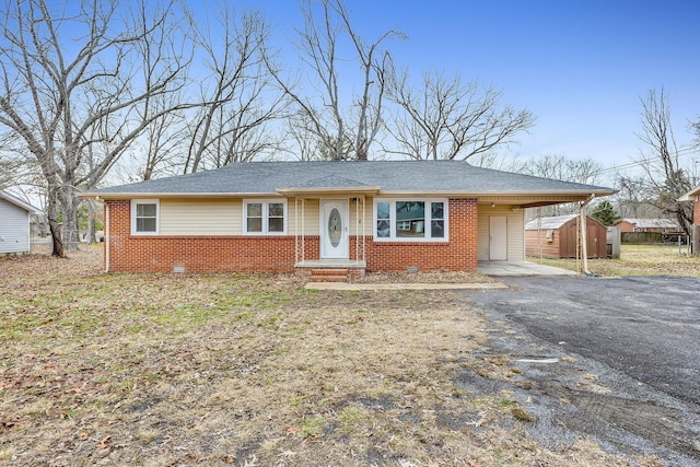 single story home with a carport and a storage unit