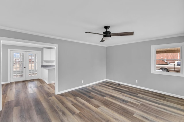 empty room featuring crown molding, dark wood-type flooring, french doors, and ceiling fan