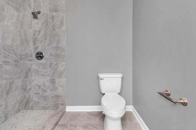 bathroom featuring tiled shower and toilet