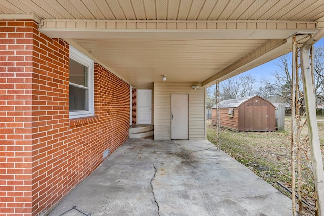 view of patio / terrace with a carport and a storage unit