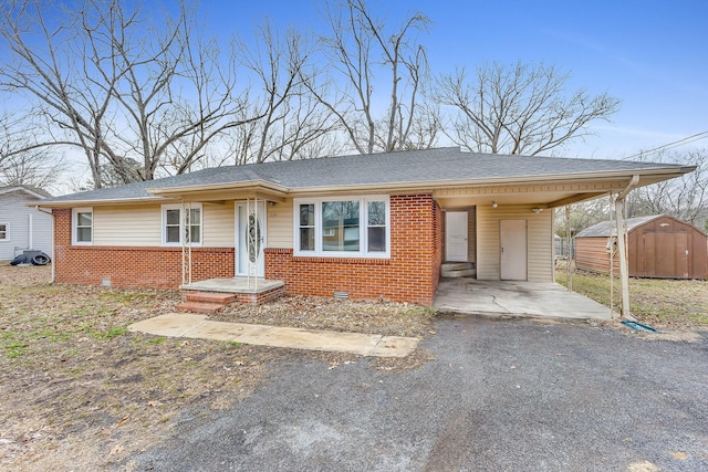 view of front of house with a carport and a storage unit