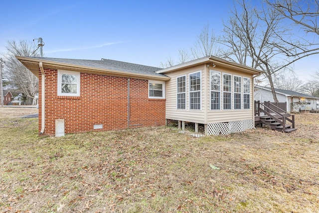 back of house featuring a yard and a sunroom