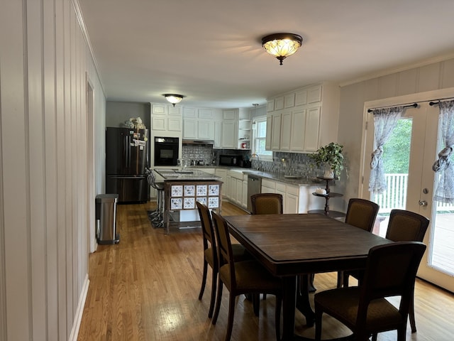 dining room with crown molding, plenty of natural light, and light wood-type flooring