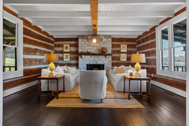 living room with a stone fireplace, wood-type flooring, a healthy amount of sunlight, and wood walls