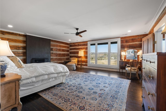 bedroom with crown molding, dark wood-type flooring, ceiling fan, and wood walls