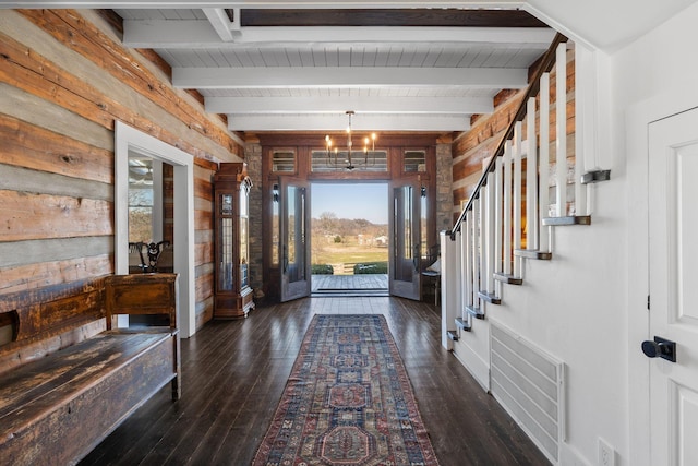 foyer with an inviting chandelier, dark hardwood / wood-style flooring, and beamed ceiling