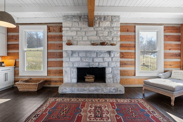 unfurnished living room with a fireplace, wooden walls, and a wealth of natural light