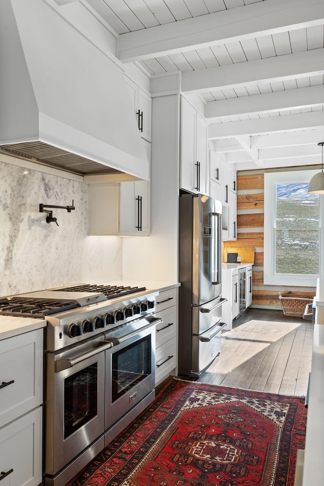 kitchen with stainless steel appliances, beam ceiling, custom exhaust hood, and white cabinets