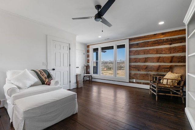 living area with ornamental molding, dark hardwood / wood-style floors, and ceiling fan