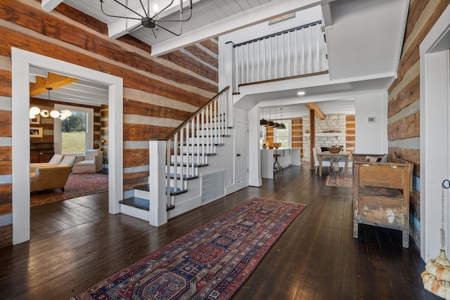 entryway with a notable chandelier, beam ceiling, and dark hardwood / wood-style floors