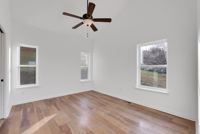 empty room featuring ceiling fan, a wealth of natural light, and light hardwood / wood-style floors