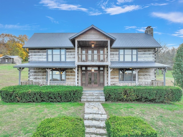 view of front of house with french doors, a porch, and a front yard