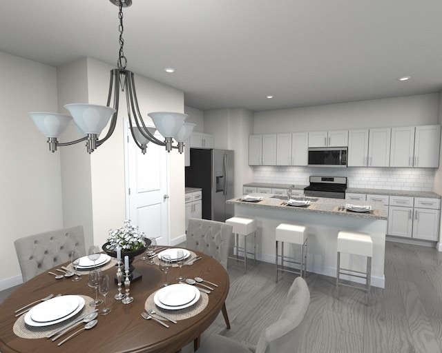 kitchen featuring appliances with stainless steel finishes, white cabinetry, backsplash, light stone counters, and a center island with sink