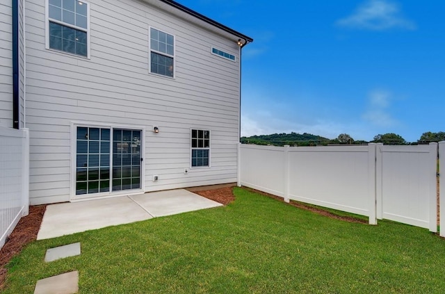 rear view of property featuring a lawn and a patio area