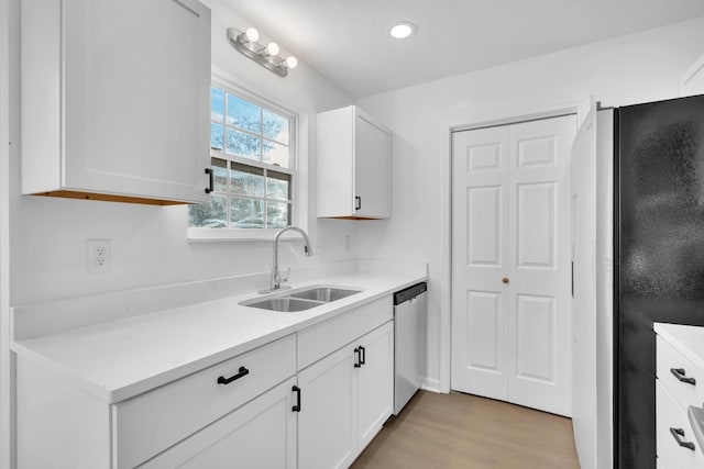 kitchen with white cabinetry, sink, light wood-type flooring, and appliances with stainless steel finishes