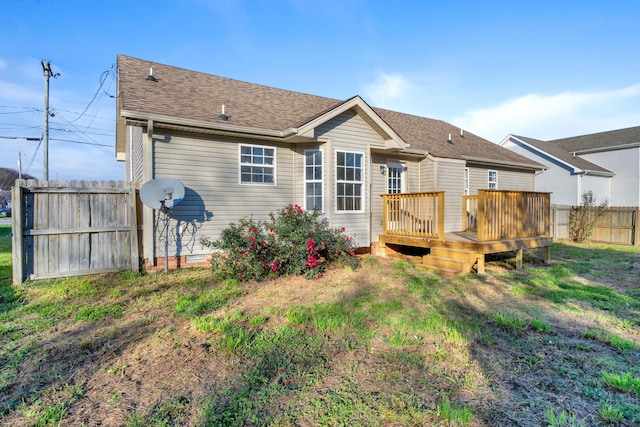 back of house featuring a wooden deck and a lawn