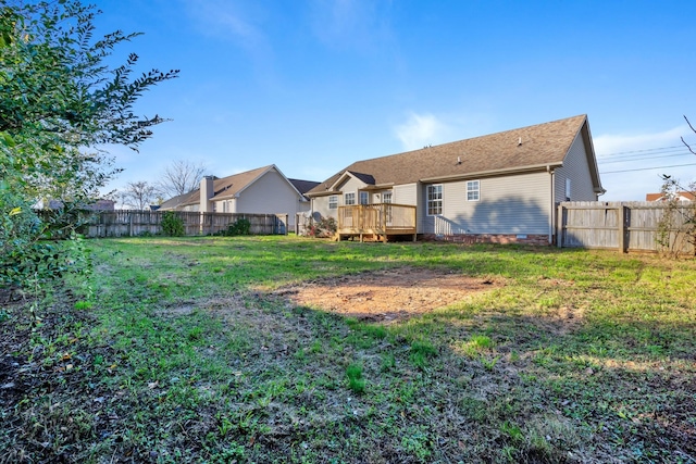 rear view of property with a wooden deck and a lawn