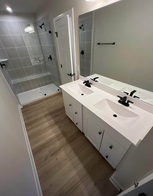 bathroom featuring vanity, hardwood / wood-style floors, and a tile shower