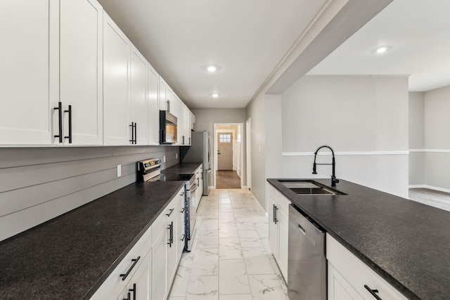 kitchen with sink, dark stone counters, white cabinets, and appliances with stainless steel finishes