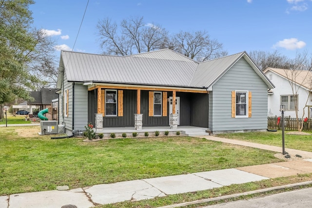 view of front of house featuring cooling unit, a front lawn, and a porch